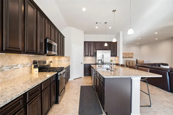 a large kitchen with lots of counter space a sink and appliances