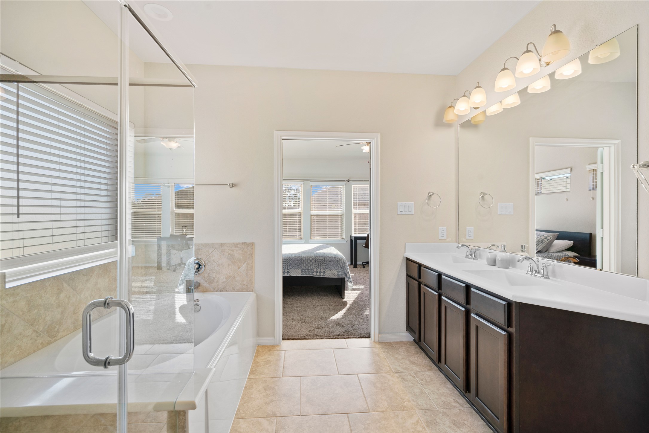 14300 Congaree Court Conroe, TX 77384 - Photo 18 of 31 a en suite bathroom with a double vanity sink a mirror and a shower
