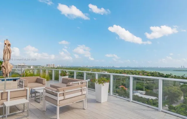 a view of a terrace with lawn chairs and iron fence