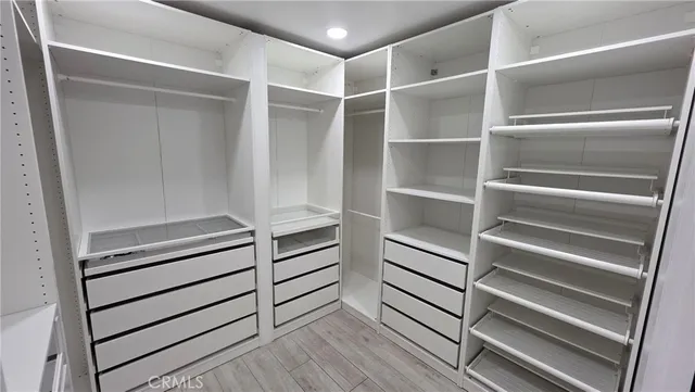 a view of walk in closet with empty racks