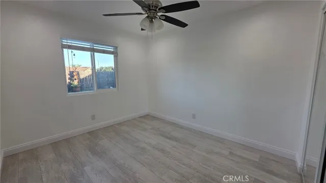 an empty room with a window and a ceiling fan