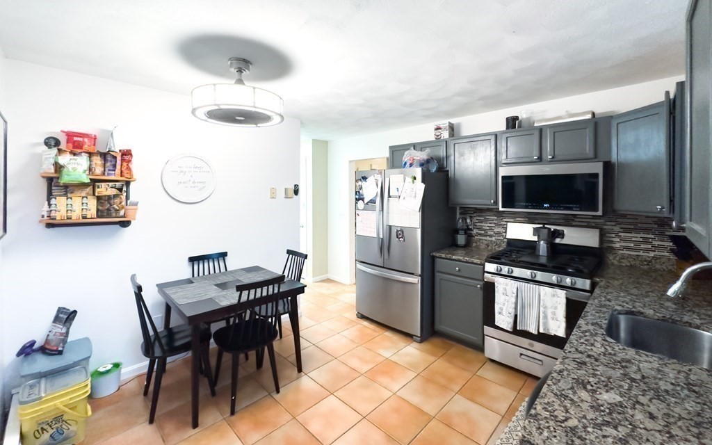 308 Acropolis Road Lowell, MA 01854 - Photo 11 of 21 a kitchen with stainless steel appliances granite countertop a refrigerator and a stove top oven