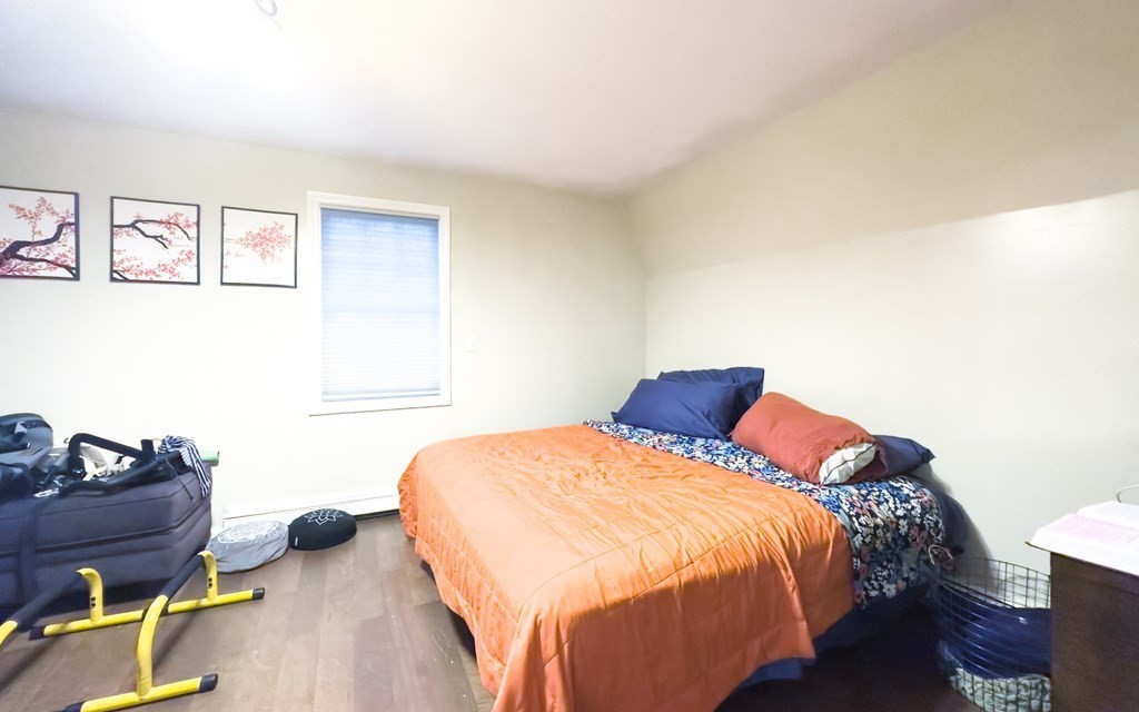 308 Acropolis Road Lowell, MA 01854 - Photo 13 of 21 a bedroom with a bed and wooden floor