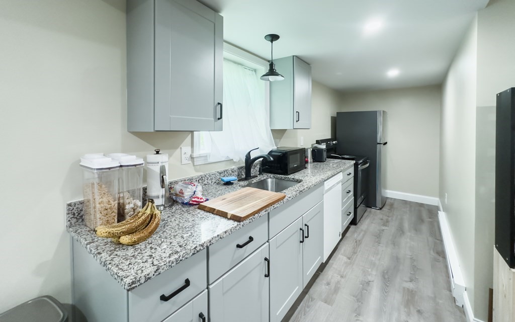 308 Acropolis Road Lowell, MA 01854 - Photo 19 of 21 a kitchen with stainless steel appliances granite countertop a sink stove and refrigerator