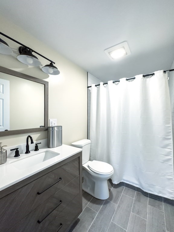 308 Acropolis Road Lowell, MA 01854 - Photo 21 of 21 a bathroom with a double vanity sink toilet and a mirror