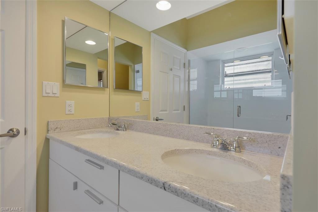 3578 Midas Place Naples, FL 34105 - Photo 11 of 21 a bathroom with a granite countertop sink a large mirror and a
