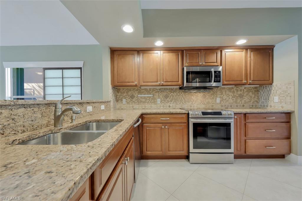 3578 Midas Place Naples, FL 34105 - Photo 16 of 21 a kitchen with stainless steel appliances granite countertop a sink and stove top oven