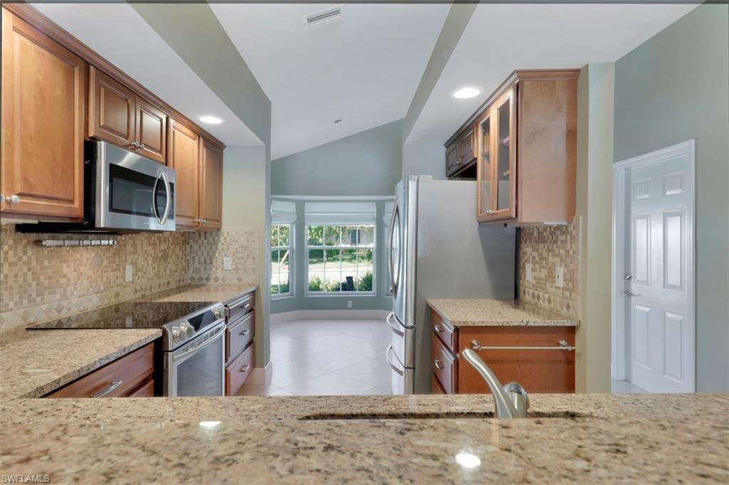 3578 Midas Place Naples, FL 34105 - Photo 7 of 21 a kitchen with stainless steel appliances granite countertop a refrigerator a stove top oven a sink and dishwasher
