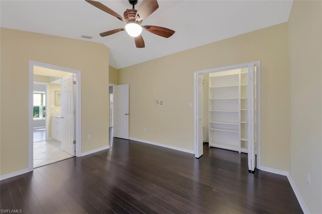 3578 Midas Place Naples, FL 34105 - Photo 10 of 21 an empty room with wooden floor chandelier fan and closet area