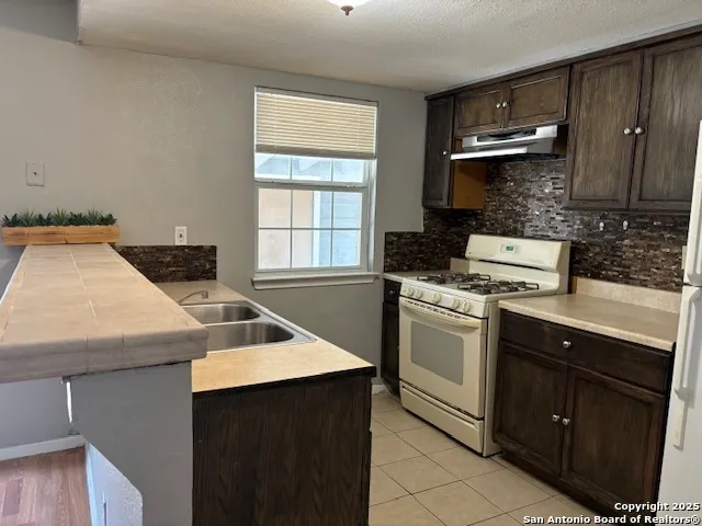 a kitchen that has a sink and a stove in it