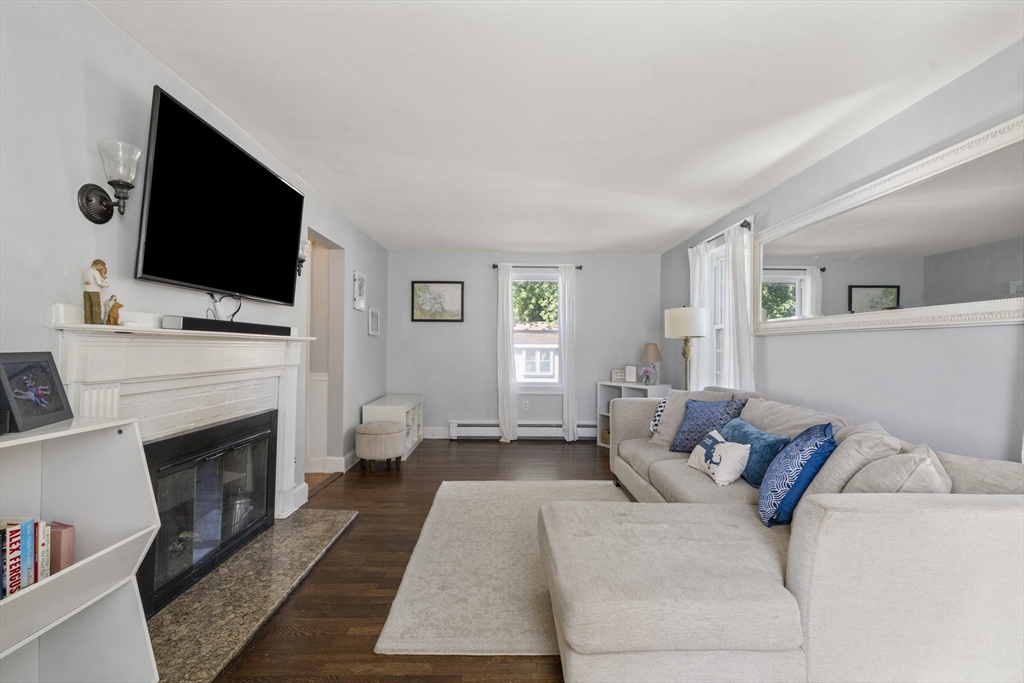 446 Ralph Talbot Street Weymouth, MA 02190 - Photo 5 of 28 a living room with furniture a flat screen tv and a fireplace