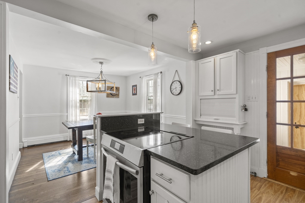 446 Ralph Talbot Street Weymouth, MA 02190 - Photo 6 of 28 a kitchen with granite countertop a sink a stove and cabinets