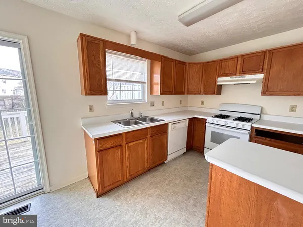 a kitchen with white cabinets sink and white appliances