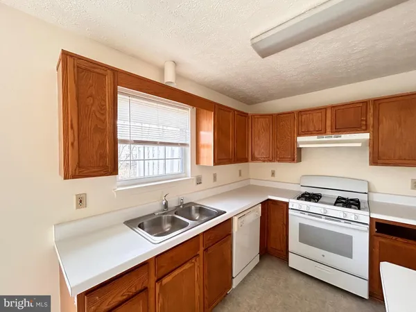 a kitchen with a sink stove top oven and cabinets