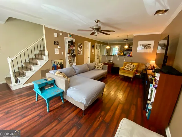 a living room with furniture and a wooden floor