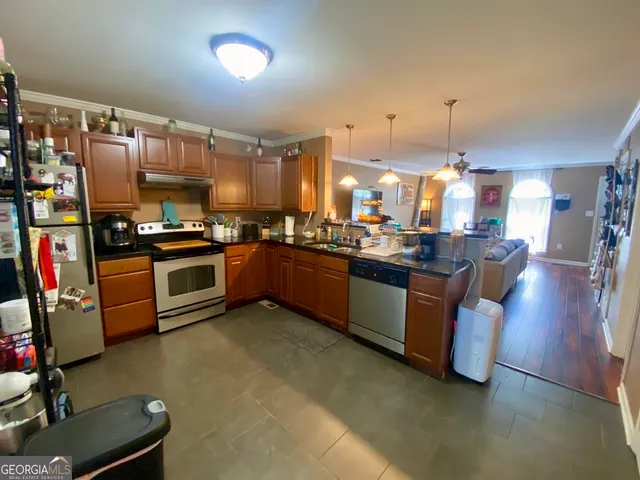 a kitchen with stainless steel appliances granite countertop a stove a sink dishwasher and a refrigerator