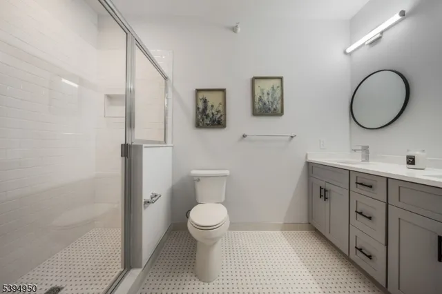 a bathroom with a toilet sink double vanity and mirror