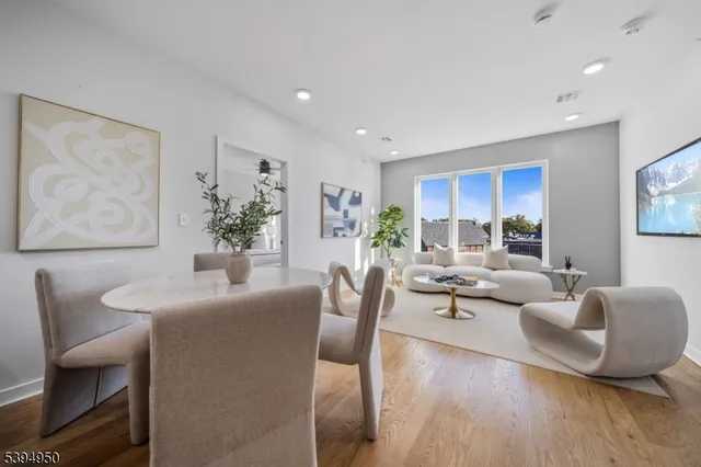 a living room with furniture wooden floor and a large window