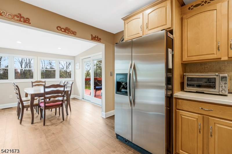 496 Rolling Hills Road Bridgewater, NJ 08807 - Photo 19 of 45 a kitchen with stainless steel appliances granite countertop a refrigerator a stove and a dining table with wooden floor