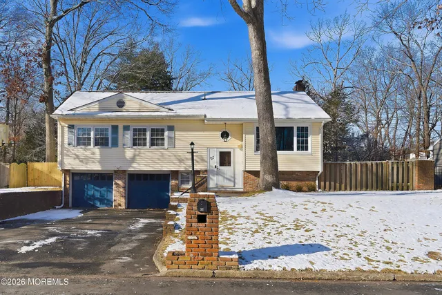 a front view of a house with a yard covered with snow
