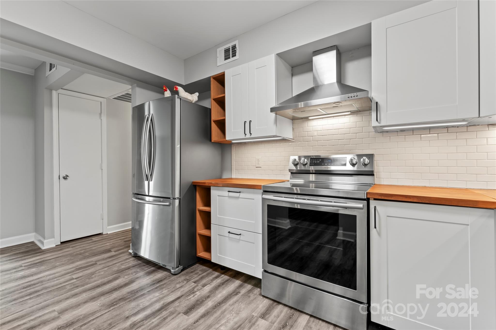 7035 Quail Hill Road Charlotte, NC 28210 - Photo 5 of 40 a kitchen with stainless steel appliances a stove a refrigerator and cabinets