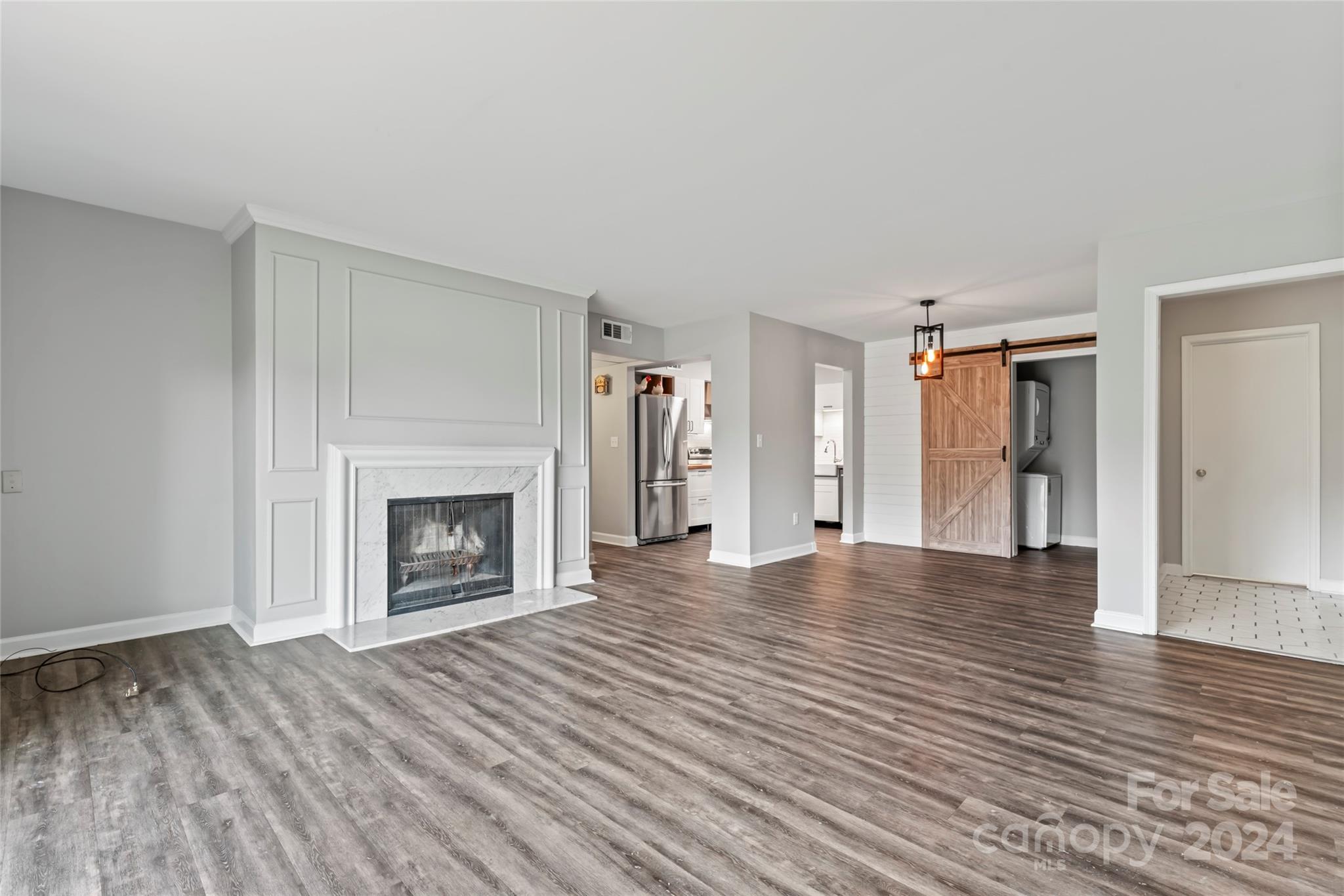 7035 Quail Hill Road Charlotte, NC 28210 - Photo 7 of 40 a view of an empty room with wooden floor fireplace and a window