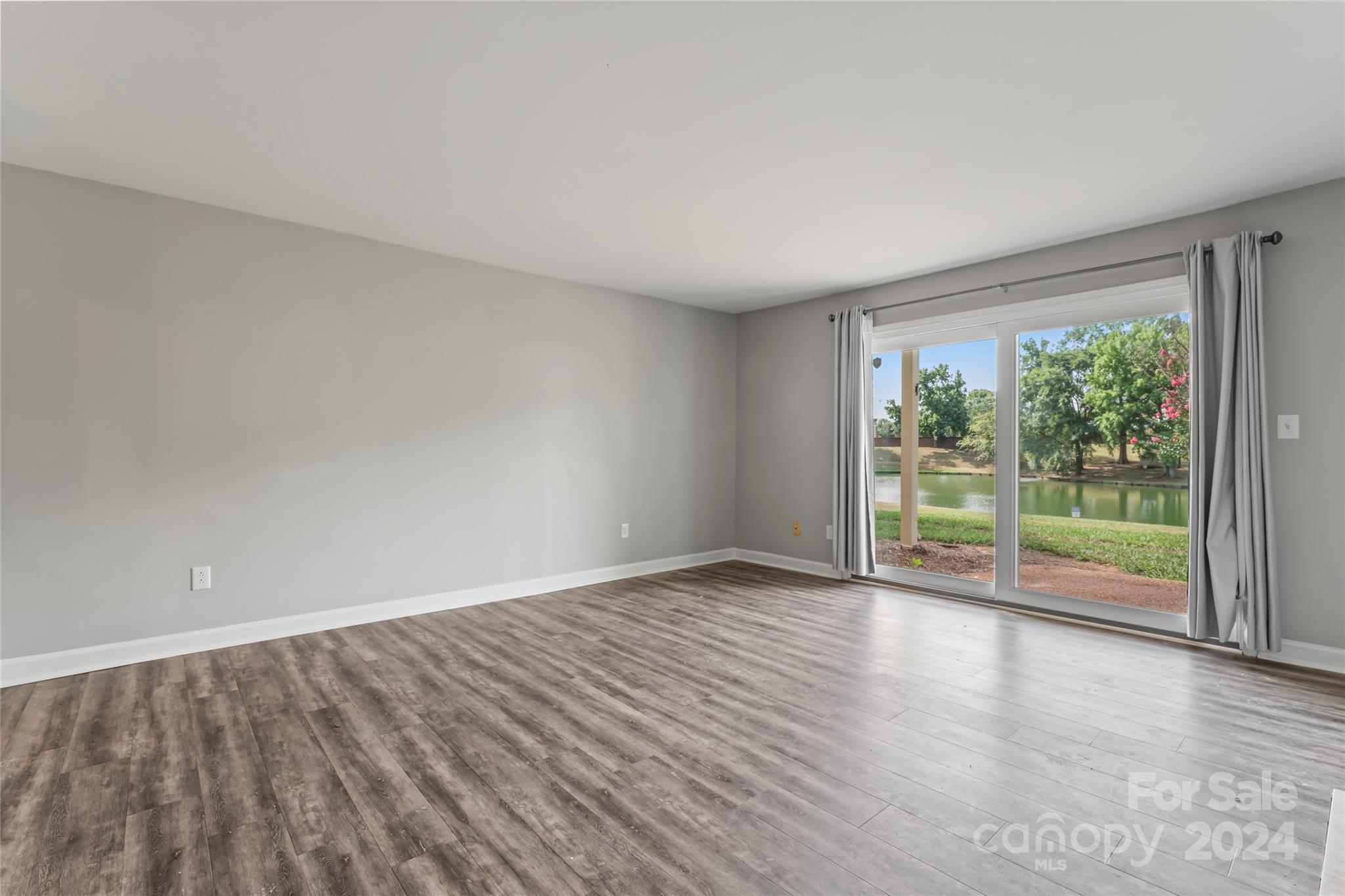 7035 Quail Hill Road Charlotte, NC 28210 - Photo 9 of 40 a view of an empty room with wooden floor and a window