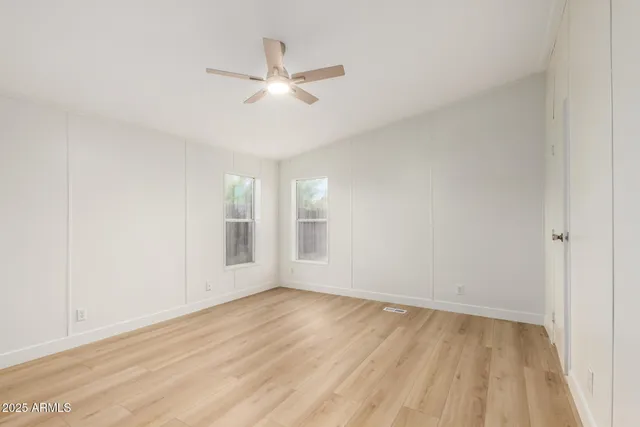 a view of empty room with wooden floor
