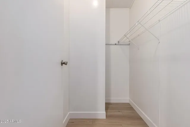 an empty room with wooden floor cabinet and windows