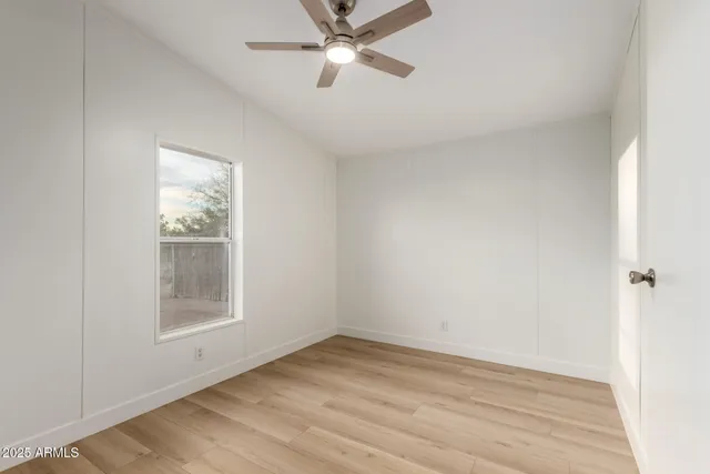 a view of an empty room with closet and a window
