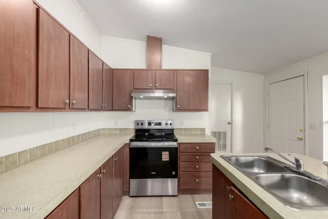 a kitchen with a sink a stove and a window