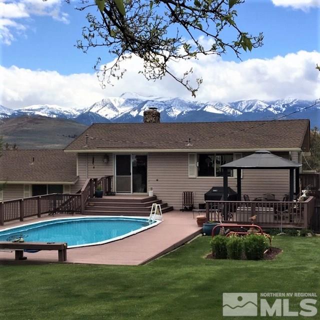 14620 Rim Rock Drive Reno, NV 89521 - Photo 3 of 23 a view of a swimming pool with lawn chairs and a big yard