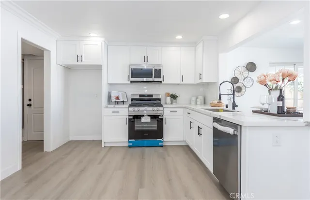 a kitchen with white cabinets and appliances