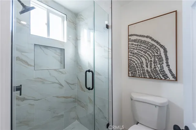 a bathroom with a toilet and a shower