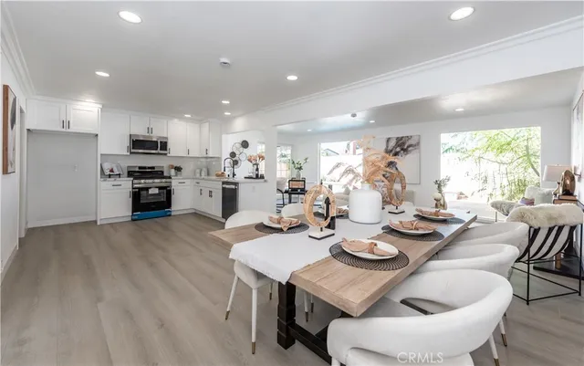 a view of a dining room with furniture a kitchen and chandelier