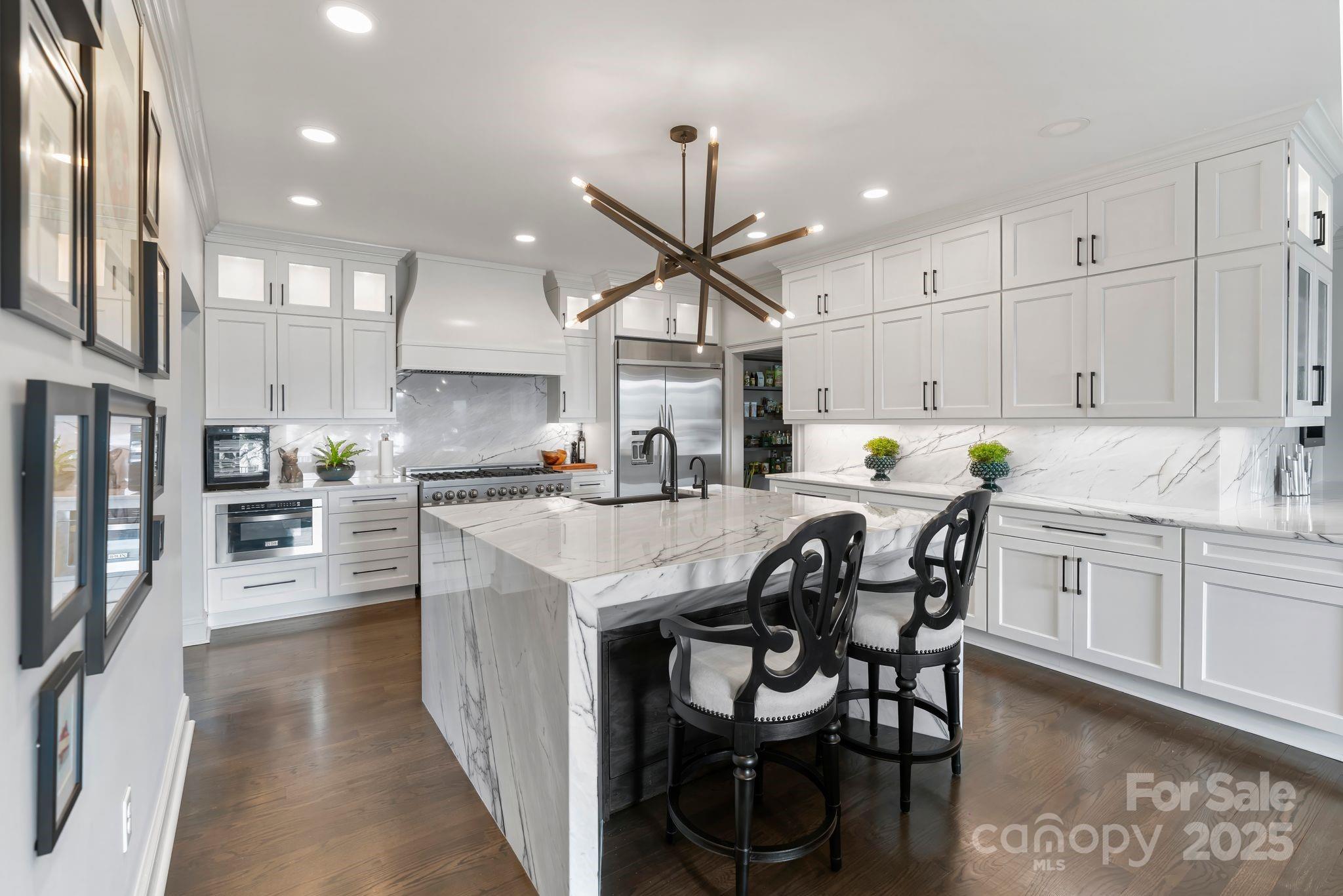 17819 John Connor Road Cornelius, NC 28031 - Photo 12 of 48 a kitchen with stainless steel appliances kitchen island granite countertop a dining table chairs refrigerator and sink