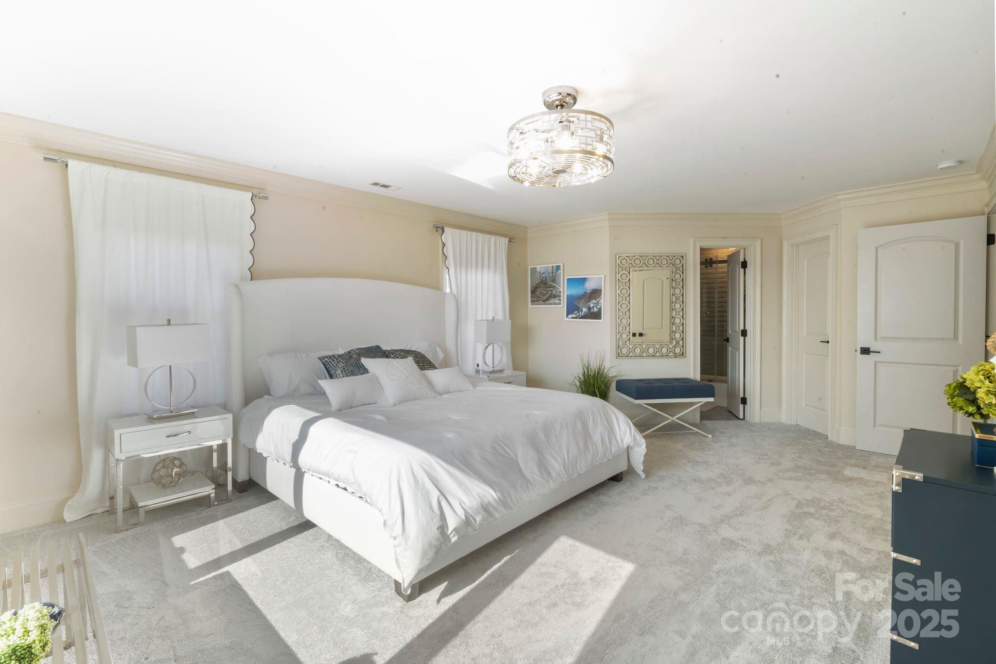 17819 John Connor Road Cornelius, NC 28031 - Photo 28 of 48 a spacious bedroom with a bed and a chandelier