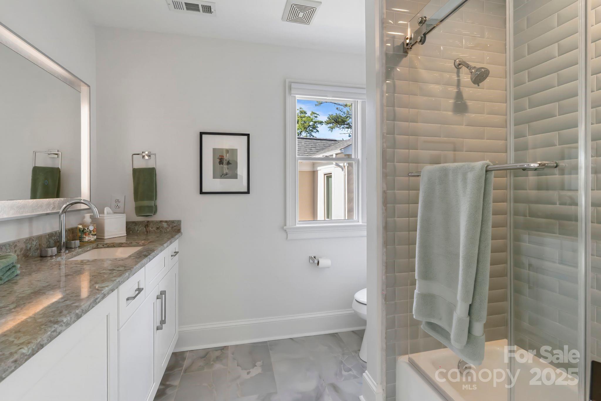 17819 John Connor Road Cornelius, NC 28031 - Photo 30 of 48 a spacious bathroom with a granite countertop sink a toilet a mirror and shower