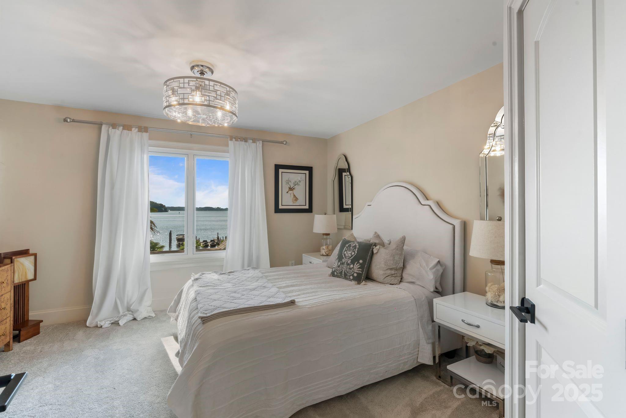 17819 John Connor Road Cornelius, NC 28031 - Photo 32 of 48 a bedroom with a bed and a chandelier