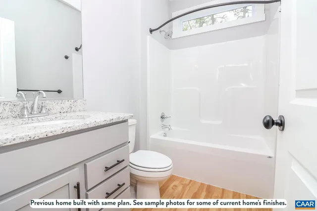 a bathroom with a granite countertop sink toilet a shower and a mirror