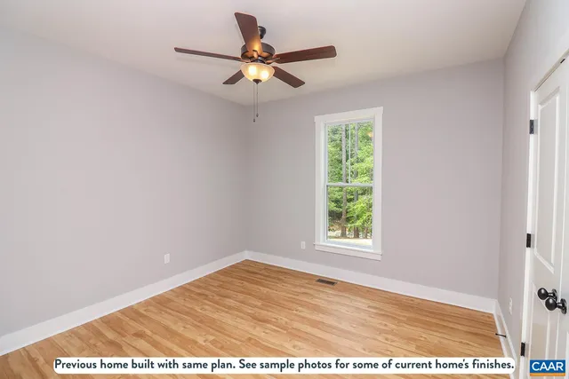 a view of a big room with wooden floor and windows