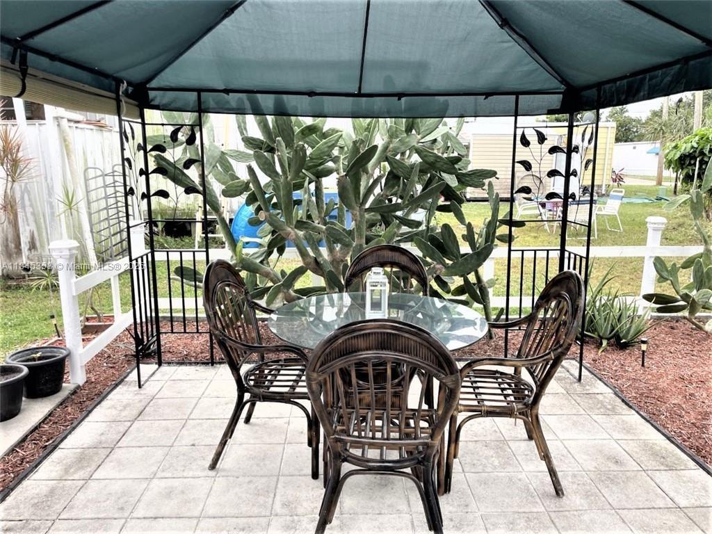 8671 Southwest 18th Place Davie, FL 33324 - Photo 20 of 22 a patio with table and chairs and potted plants