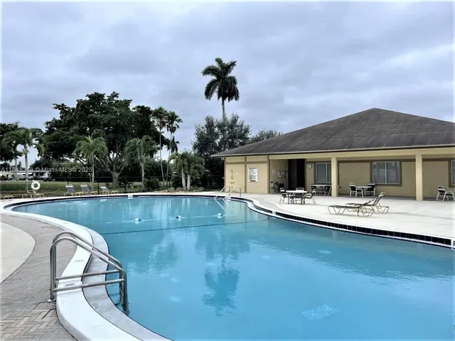 a view of a house with swimming pool and sitting area
