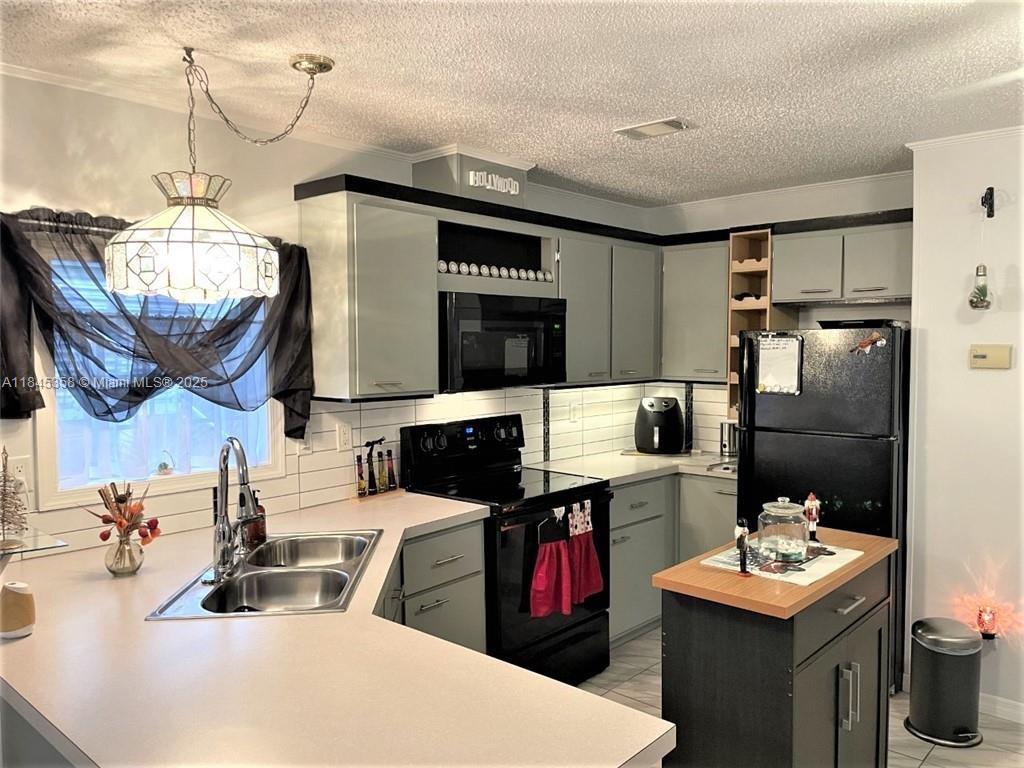 8671 Southwest 18th Place Davie, FL 33324 - Photo 3 of 22 a kitchen with stainless steel appliances kitchen island granite countertop a sink dishwasher stove and refrigerator with wooden floor