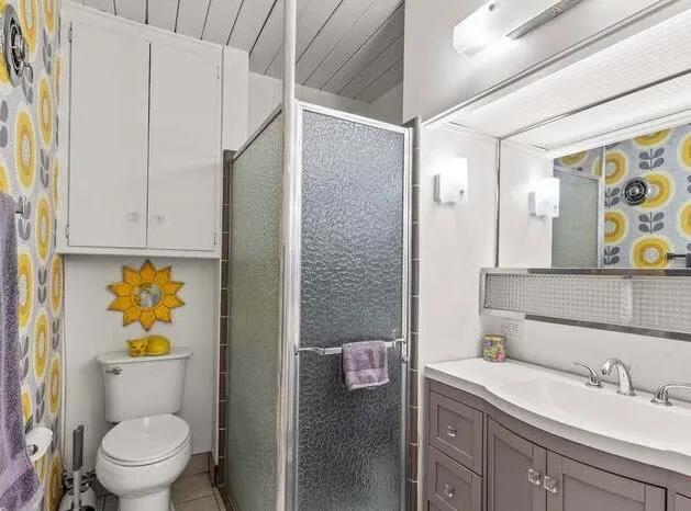 a bathroom with a granite countertop sink a toilet and shower