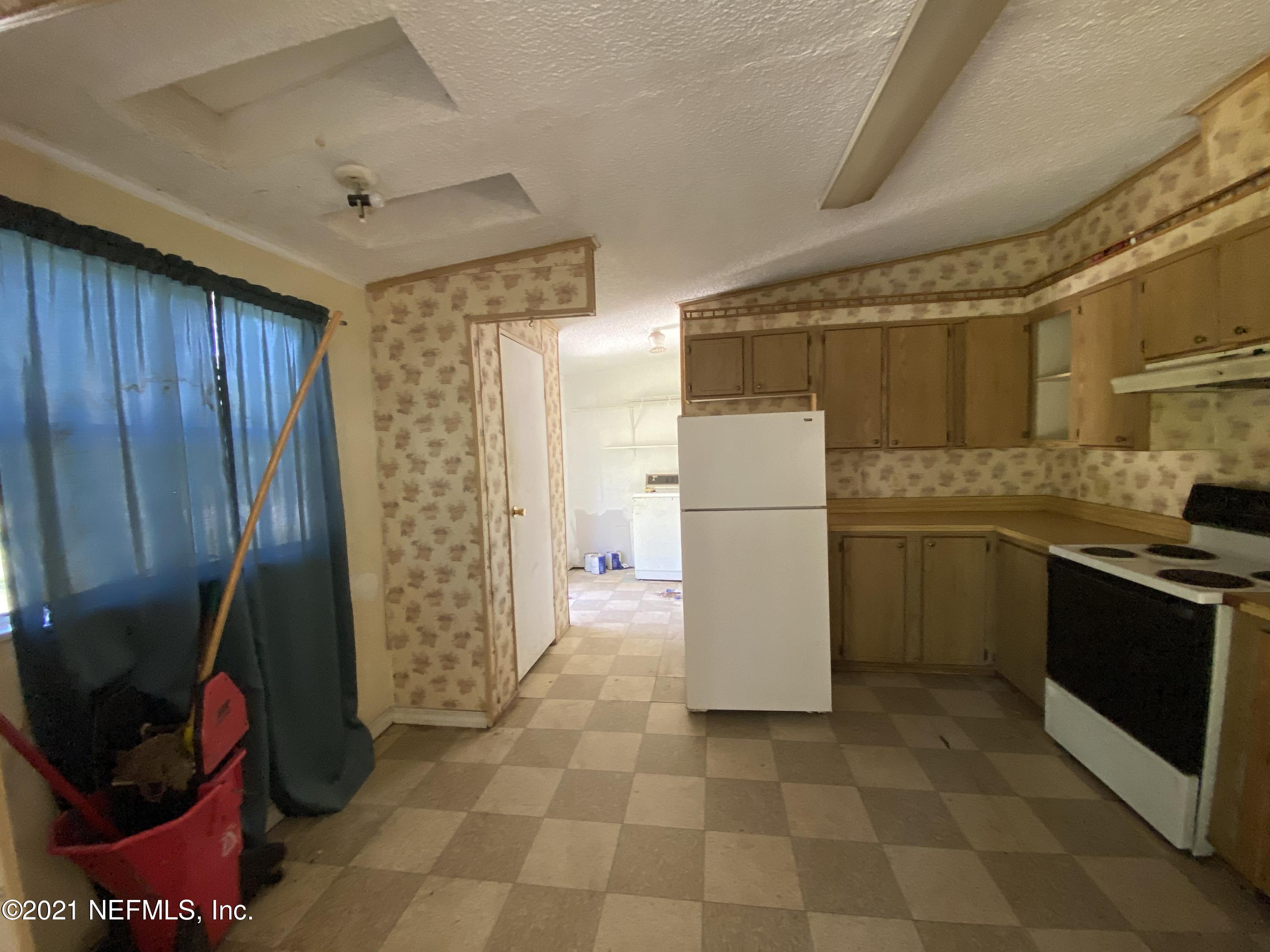6427 Firestone Road Jacksonville, FL 32244 - Photo 14 of 55 a kitchen with a refrigerator and a stove top oven
