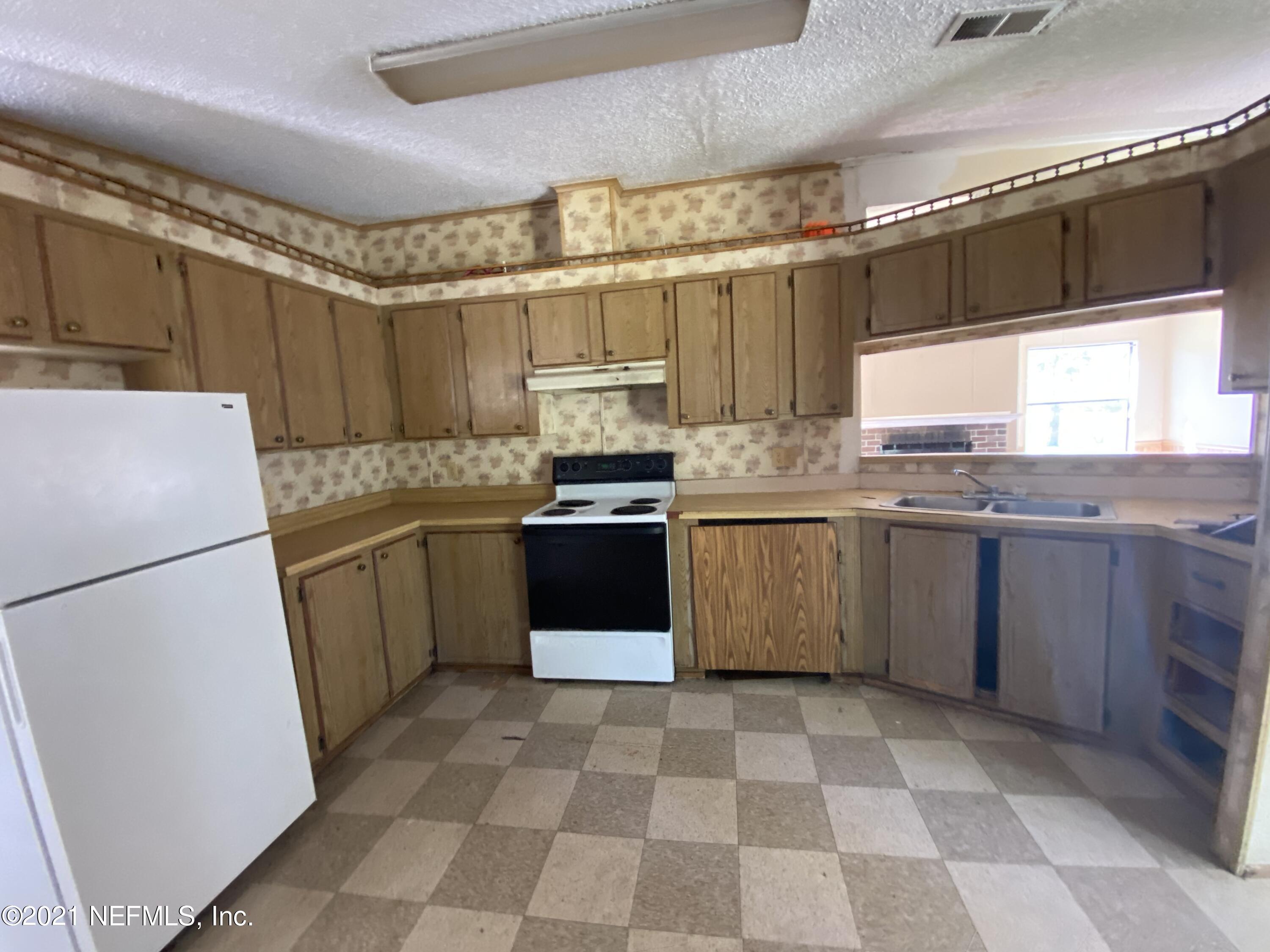 6427 Firestone Road Jacksonville, FL 32244 - Photo 15 of 55 a kitchen with a stove sink and a refrigerator