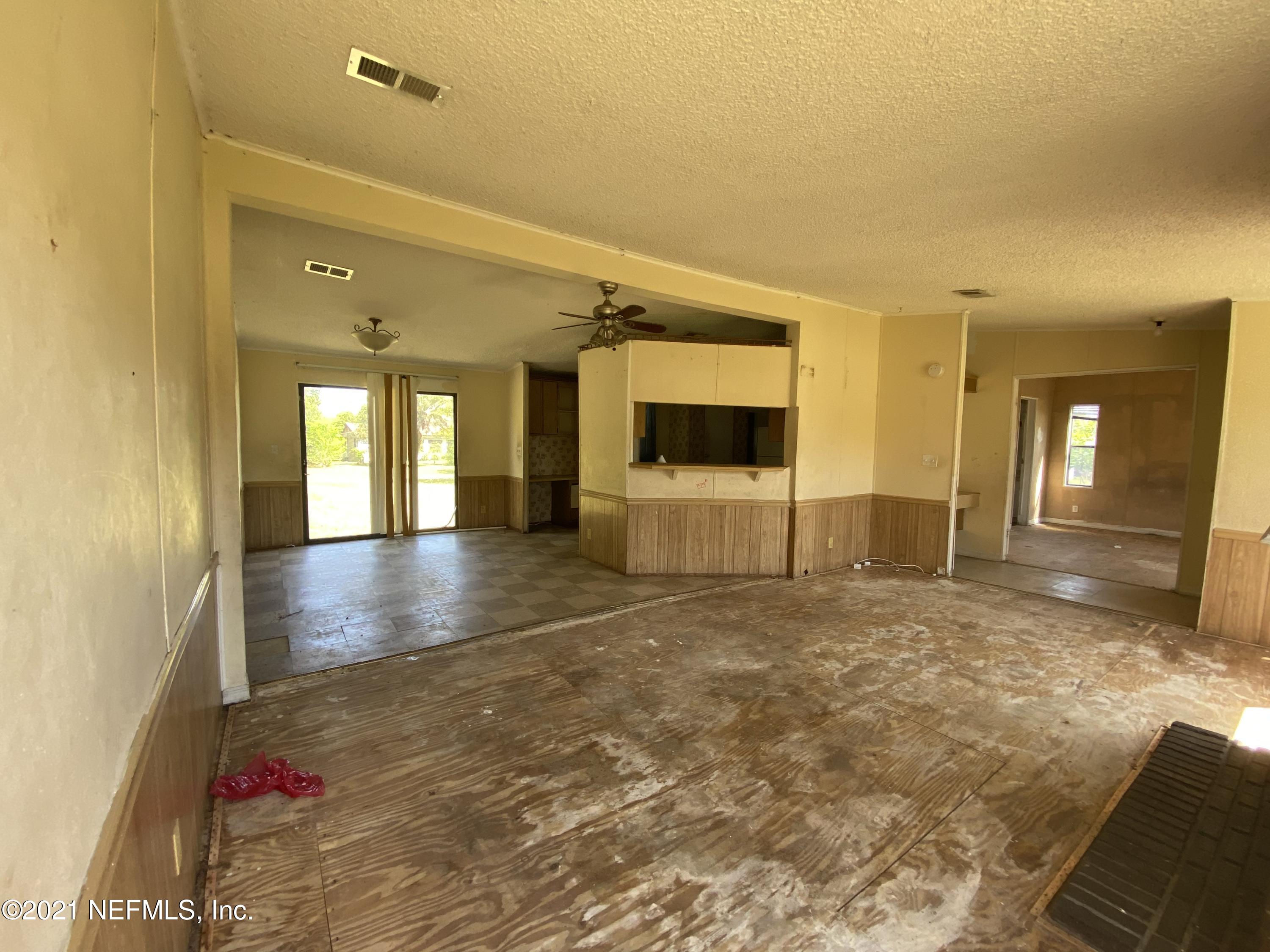 6427 Firestone Road Jacksonville, FL 32244 - Photo 18 of 55 a view of a hallway with wooden floor and a living room