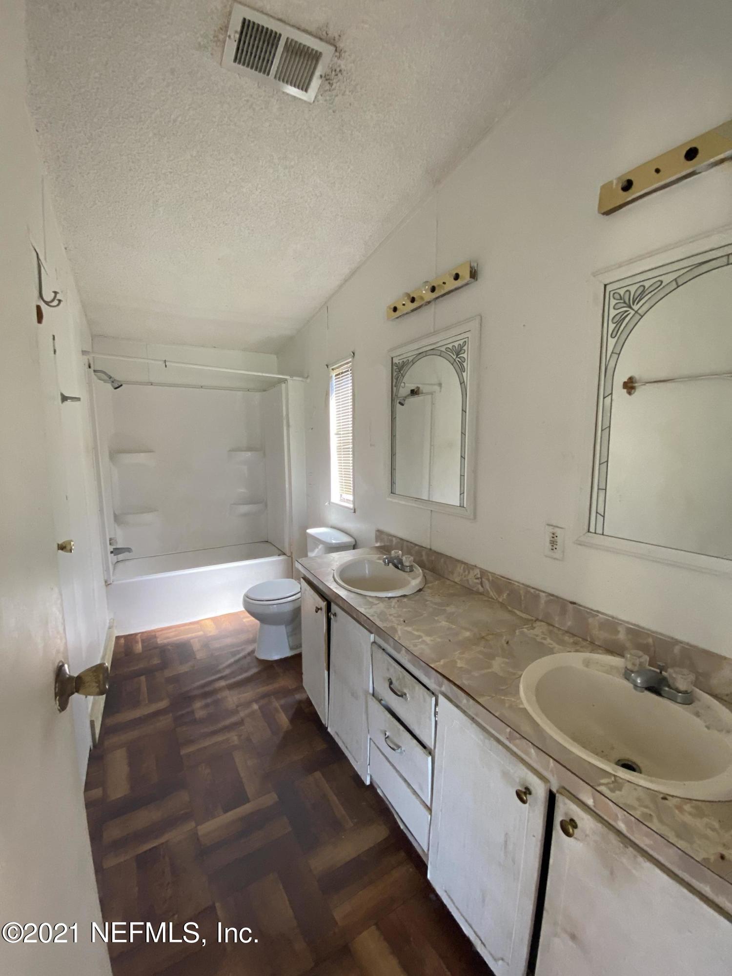 6427 Firestone Road Jacksonville, FL 32244 - Photo 23 of 55 a spacious bathroom with a granite countertop sink a toilet and shower