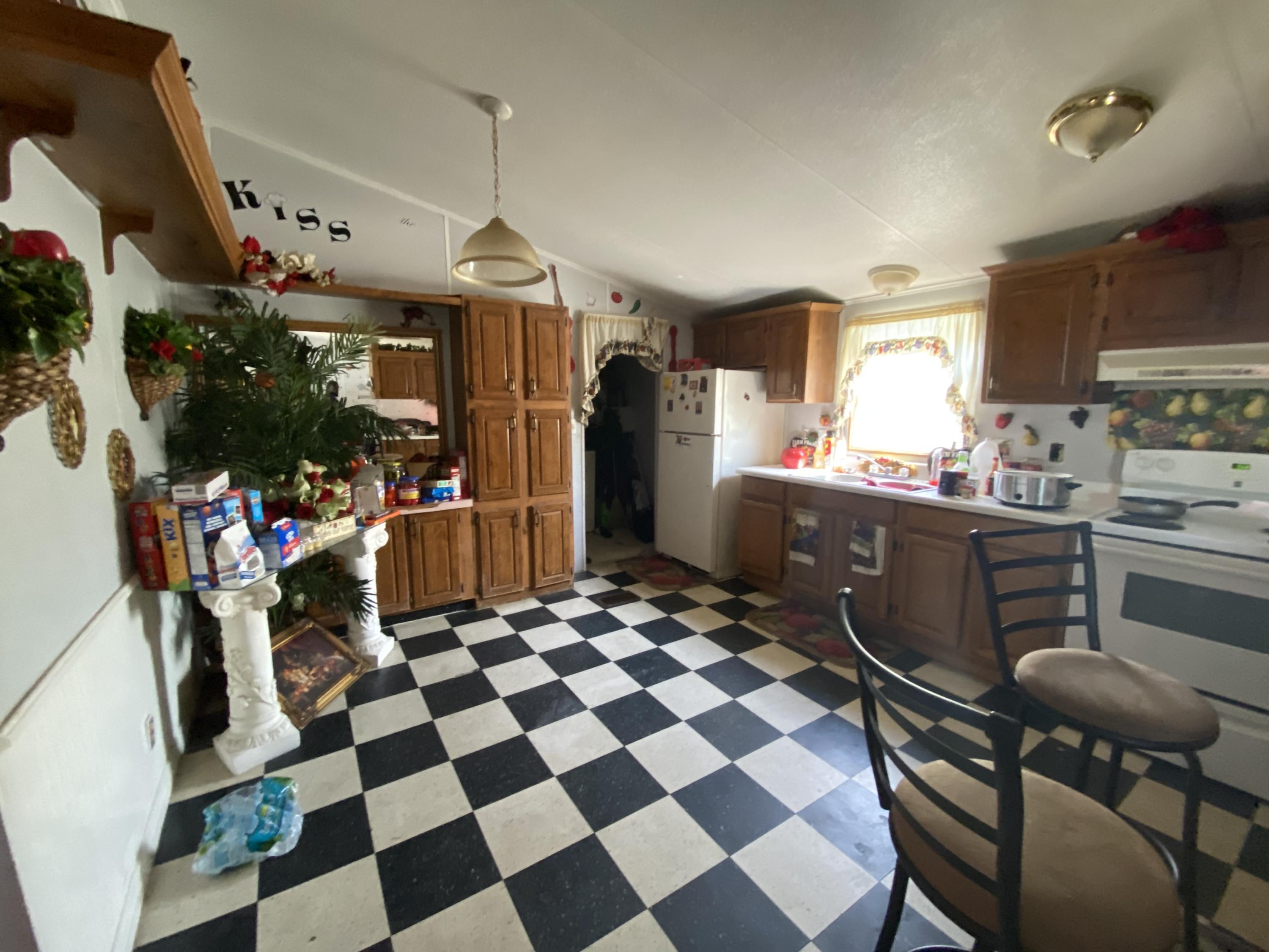 6427 Firestone Road Jacksonville, FL 32244 - Photo 36 of 55 a kitchen with a sink a refrigerator and cabinets